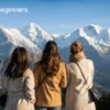 Three women overlooking snow-capped Swiss Alps at Männlichen.